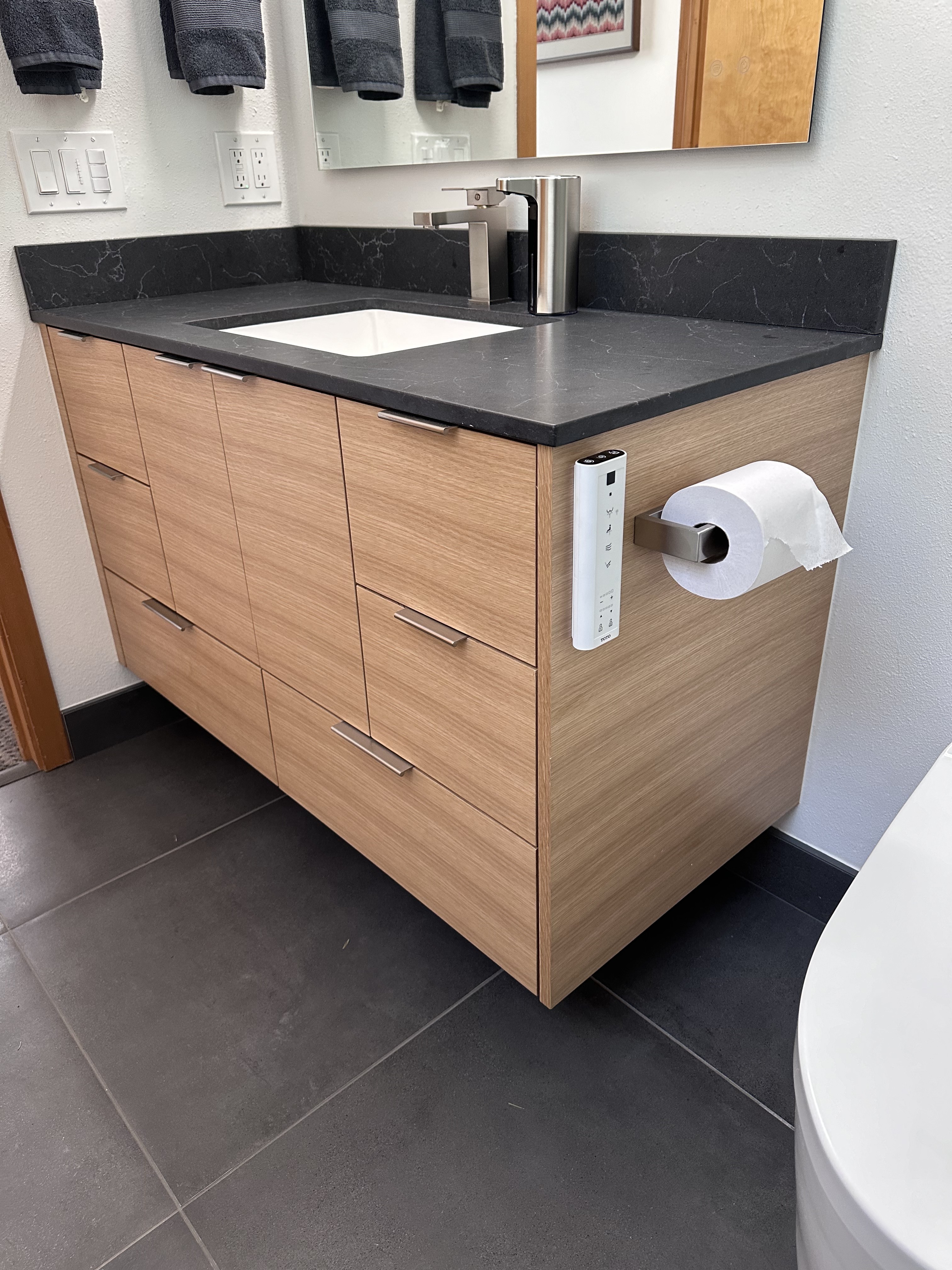 Grain-matched white oak veneer detail on frameless floating bathroom vanity