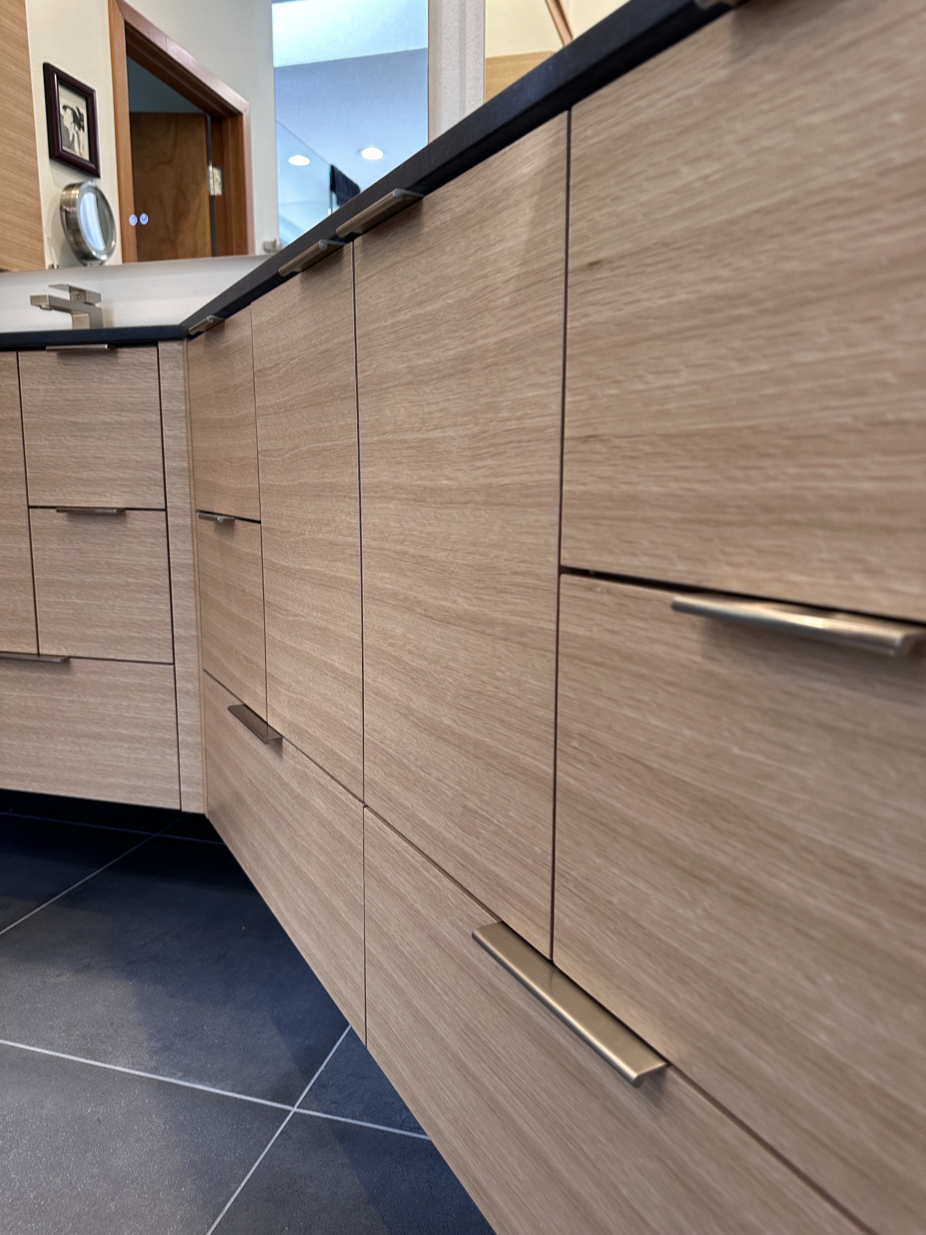 Porcelain vessel sink on floating white oak vanity with matte black fixtures